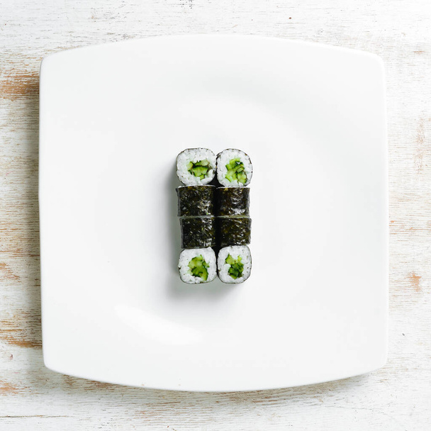 Aasialaista ruokaa. Sushi maki valkoisella lautasella. Huippunäkymä. Valkoisella pohjalla. - Valokuva, kuva
