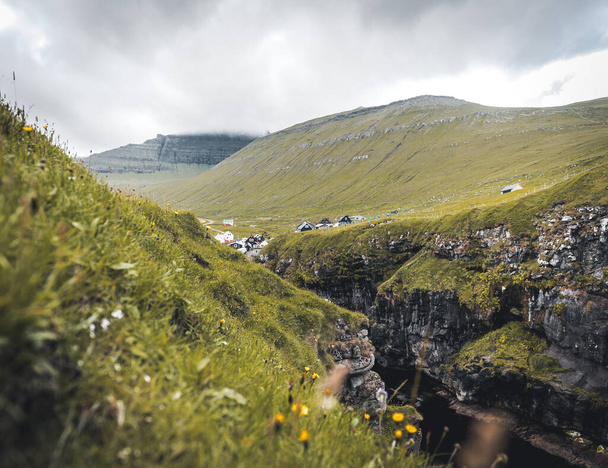 Faroe islands village of Gjogv or Gjov in Danish. Sea-filled gorge on the northeast tip of the island of Eysturoy, in the Faroe Islands. - Φωτογραφία, εικόνα