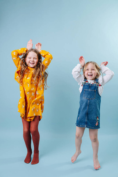 Funny little sisters making easter bunny ears gesture with hands - Fotografie, Obrázek