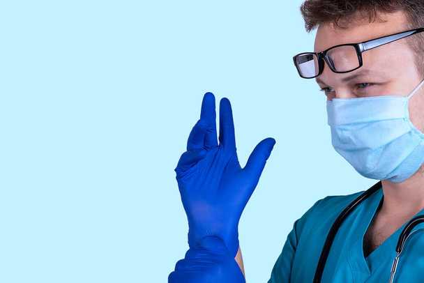 Surgeon's hand in a sterile glove on a blue background - Foto, Imagen