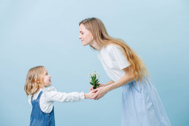 Little girl gives her mother bouquet of wild camomiles - Foto, Imagen