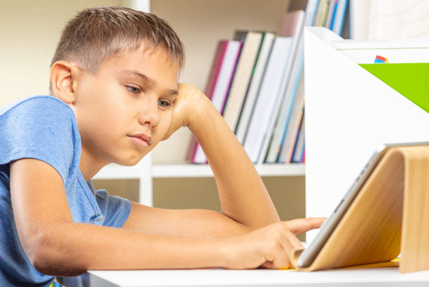 Εφηβικό αγόρι που χρησιμοποιεί ψηφιακό υπολογιστή tablet. Ηλεκτρονική μάθηση, εξ αποστάσεως εκπαίδευση, εξ αποστάσεως μαθήματα, ψυχαγωγία στο σπίτι - Φωτογραφία, εικόνα