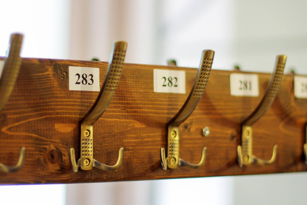 wardrobe, clothes hooks are numbered. coat rack with hooks for coats and jackets in a museum. an empty wardrobe during a pandemic - Foto, Bild