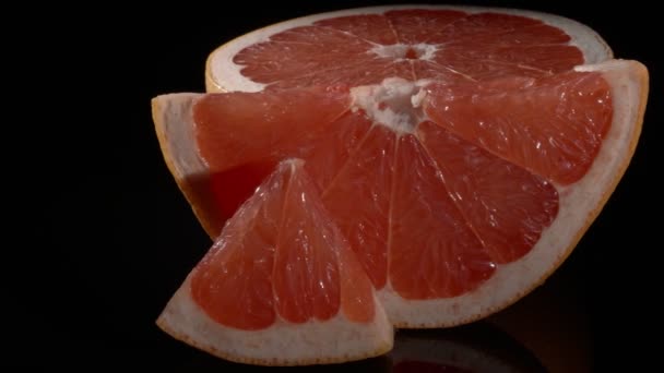 Grapefruit közelkép fekete háttérrel. Az egészséges táplálkozás fogalma. - Felvétel, videó