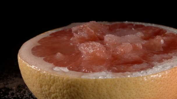 Grapefruit met suiker in zijn eigen sap close-up. Zwarte achtergrond. - Video