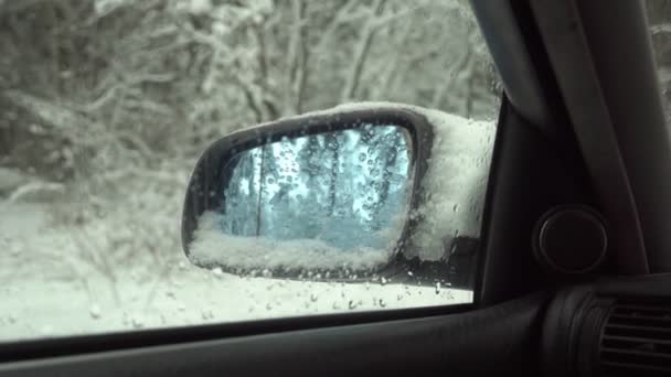 Zijspiegel van de auto close-up van het interieur sneeuw winterbos. - Video