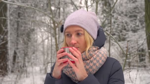 young woman drinking hot drink. Steam from hot coffee or tea. Winter camping. - Footage, Video