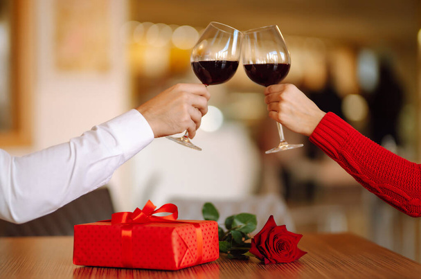 Clinking glasses with red wine. Romantic dinner. Valentines day, romantic date and holidays concept. - Foto, immagini