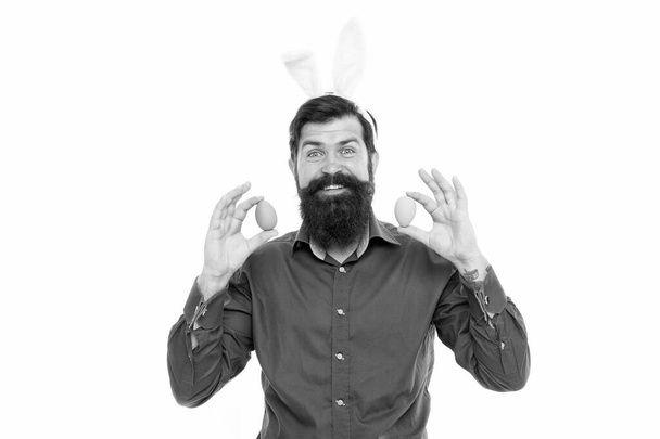 Eggs are dearest at Easter. Easter bunny delivering colored eggs. Bearded man hold Easter eggs. Hipster with long rabbit ears. Egg laying hare. Celebrating Easter. Holiday celebration. Spring time - Foto, imagen