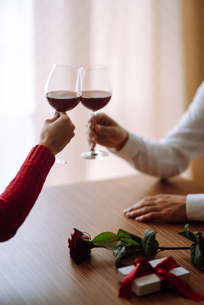 Clinking glasses with red wine. Romantic dinner. Valentines day, romantic date and holidays concept. - Photo, Image