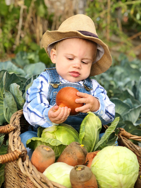 Gyerek a zöldséges kertben zöldségekkel. Szelektív fókusz. - Fotó, kép