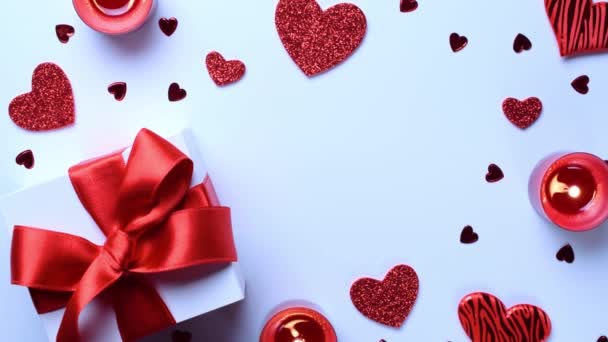 Sevgililer Günü hediye kutusu, kırmızı aşk kalpleri, beyaz arka planda romantik bir mum. Kopya alanı ile romantik mesaj şablonu. Üst Manzara. Yukarıdan görüntüle - Video, Çekim