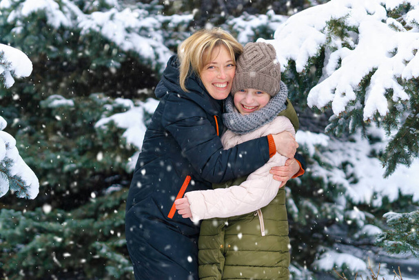 äiti ja tytär perheen muotokuva talvimetsässä, toinen vanhempi ja yksi lapsi, kaunis luonto kirkkailla lumisilla kuusilla - Valokuva, kuva