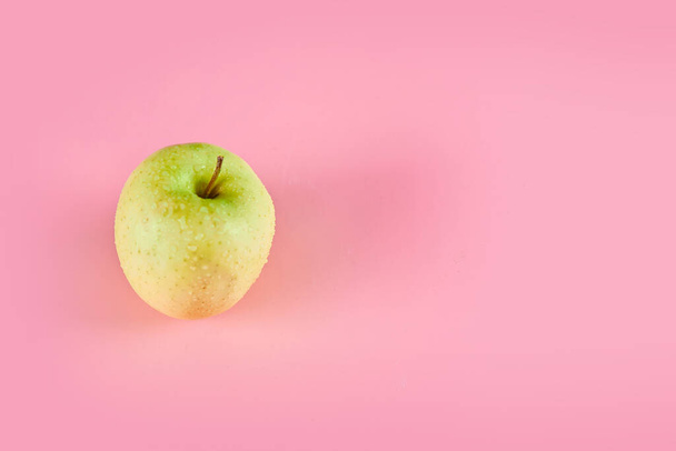 Fresh juicy green apple isolated on a pink background - Fotó, kép