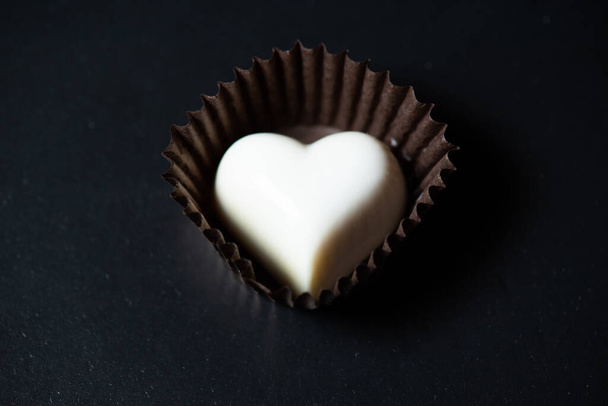 шоколадное сердце в форме черного ящика на темном фоне - Фото, изображение