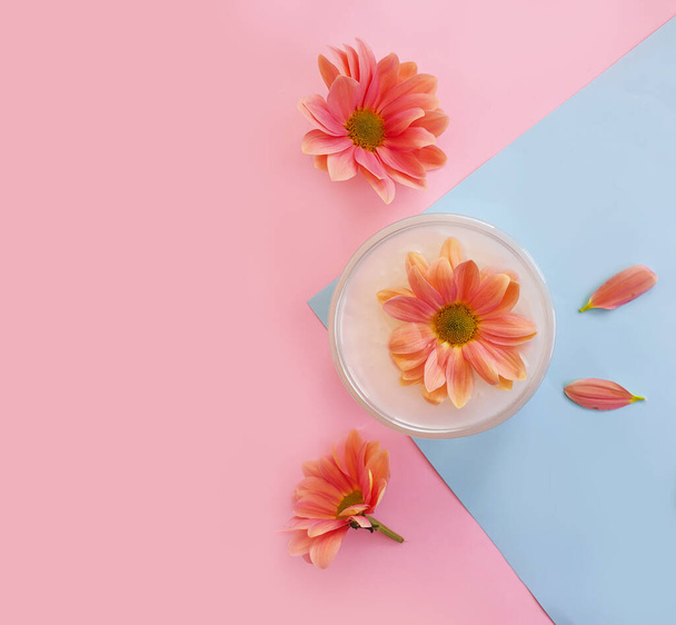 καλλυντική κρέμα, λουλούδι σε χρωματιστό φόντο - Φωτογραφία, εικόνα