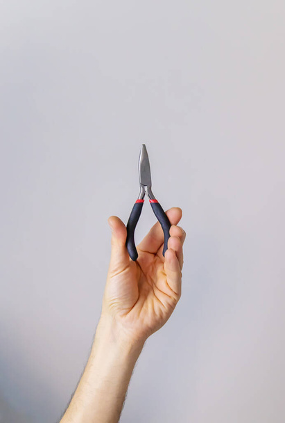 pliers for repair in the hands of a male isolate. Selective focus. People. - Foto, imagen