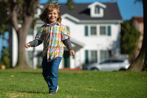 Carefree childhood. Happy smiling Boy child walk on spring lawn. - Fotoğraf, Görsel