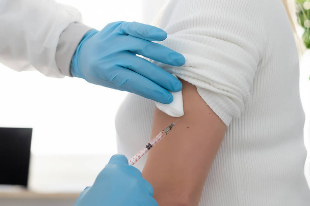 Lekarz wstrzykujący szczepionkę kobiecie, szczepionkę przeciw wirusowi zakaźnemu - Zdjęcie, obraz