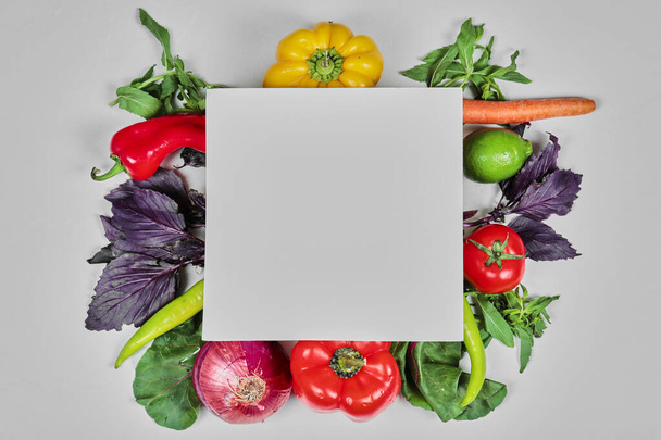 Verduras frescas, zanahorias, pimientos, verduras, zanahorias, cebolla alrededor del papel blanco - Foto, Imagen