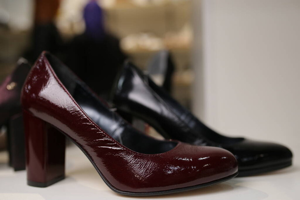 Stylish leather, lacquered women's shoes on the shelf in the store. women's shoes on the stand. Female style, fashion. - 写真・画像