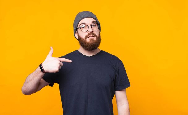 Photo of bearded man pointing at him over yellow background - Фото, изображение