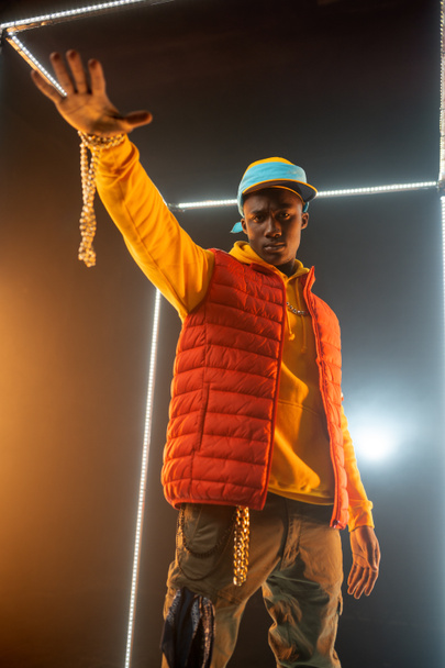 Stijlvolle rapper op het podium met verlichte kubus - Foto, afbeelding