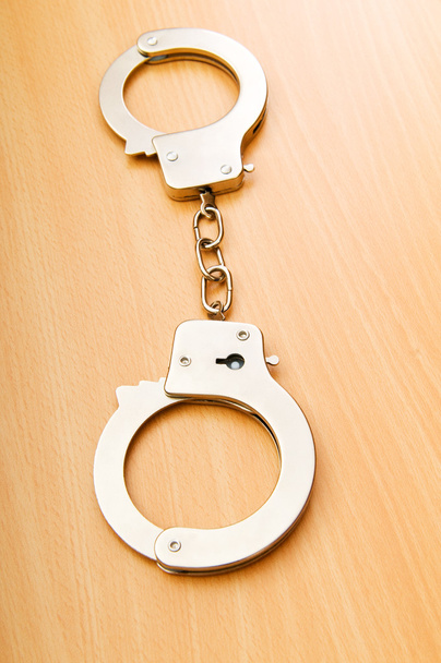 Metal handcuffs on the wooden background - Photo, Image