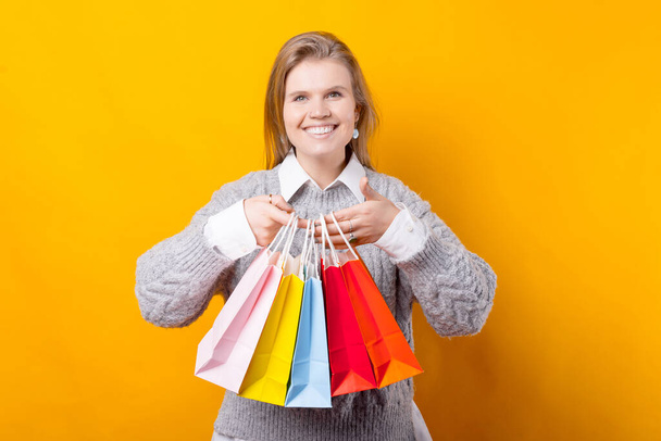 Концепція покупок, молода усміхнена жінка тримає барвисті сумки для покупок
 - Фото, зображення