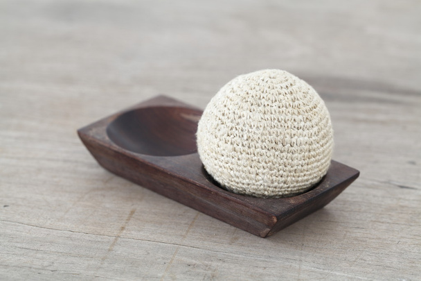 Деревянный поднос с мячом из ткани на деревянном столе
 - Фото, изображение