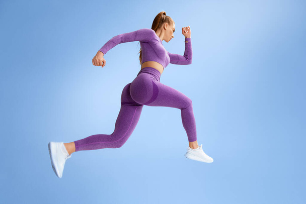 Kobieta fitness skacze i biegnie, ćwiczy. Sportowa dziewczyna robi skok - Zdjęcie, obraz