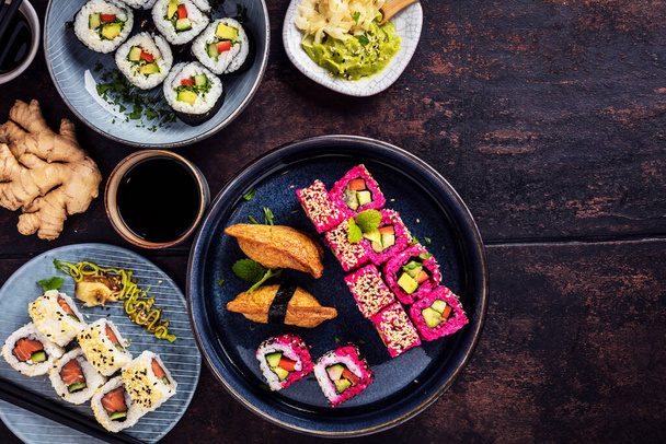 Japanese sushi food. Maki ands rolls with tuna, salmon, shrimp, crab and avocado. Assorted sushi. Rainbow sushi roll, uramaki, hosomaki and nigiri. Top view - 写真・画像