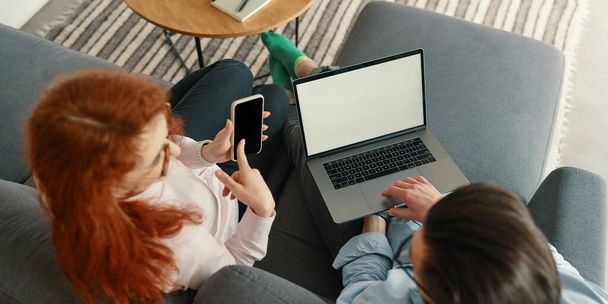 Vista superior de la familia pareja de compras en línea con ordenador portátil y teléfono inteligente - Foto, Imagen