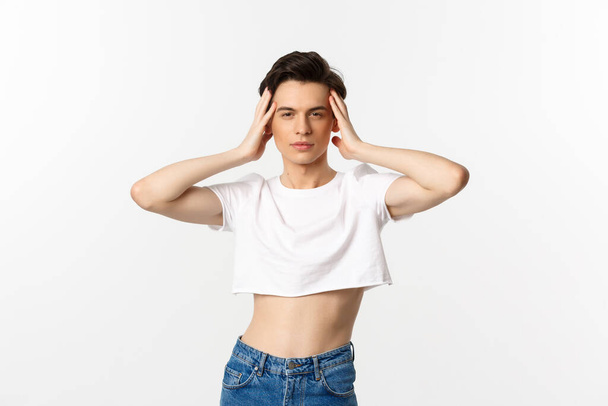Lgbtq and pride concept. Beautiful and confident gay man wearing crop top, touching face and looking sassy at camera, standing over white background - Φωτογραφία, εικόνα