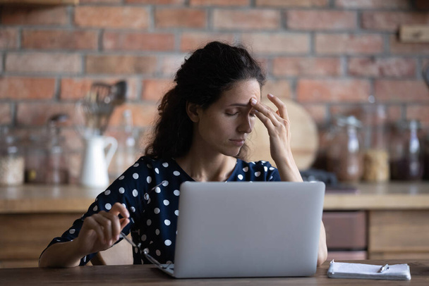 Tired woman work on laptop suffer from migraine - Foto, Bild