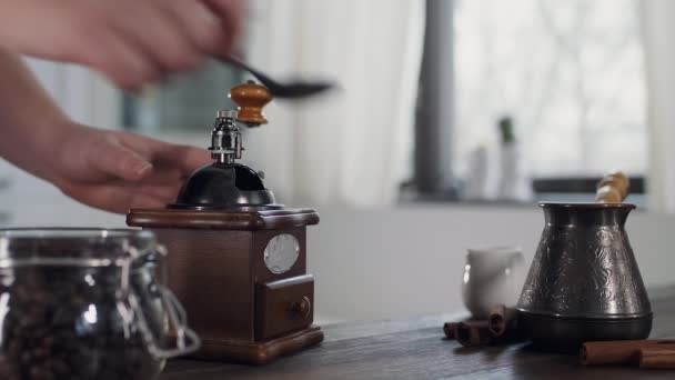 Le processus de broyage des grains de café dans un moulin rétro. Une femme prépare le café le matin. Préparation de café aromatique fraîchement moulu dans un Turc. - Séquence, vidéo