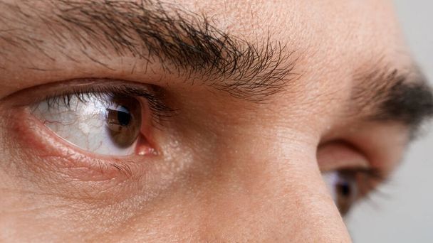 the man's eyes are close-up, close-up. male with open eyes of brown color. Health concept in the visual center. purposeful attentive gaze - Fotografie, Obrázek
