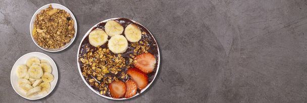 Brazialian Frozen Aa with banana and granola.Rustic background. Top View. - Photo, Image