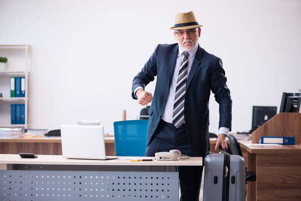 Velho funcionário do sexo masculino se preparando para viajar no escritório - Foto, Imagem