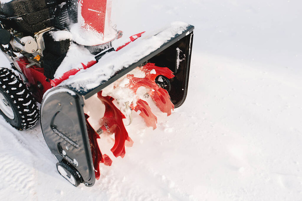 Máquina de soplador de nieve rojo-negro en el proceso de trabajo - Foto, imagen