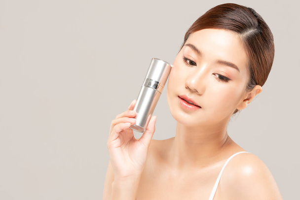Schönheit asiatische Frau halten Flasche kosmetische Creme Lotion und fröhlich. - Foto, Bild