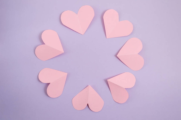 Valentine's day background. Pink hearts laid out in a circle on a pastel purple background. Valentine's day concept. Layout for postcards and congratulations. Flat lay, top view, copy space - Photo, Image