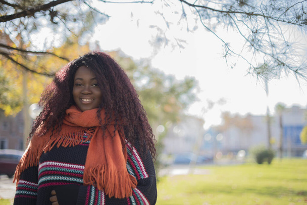 young beautiful african american woman smiling and posing in autumn park    - Фото, зображення
