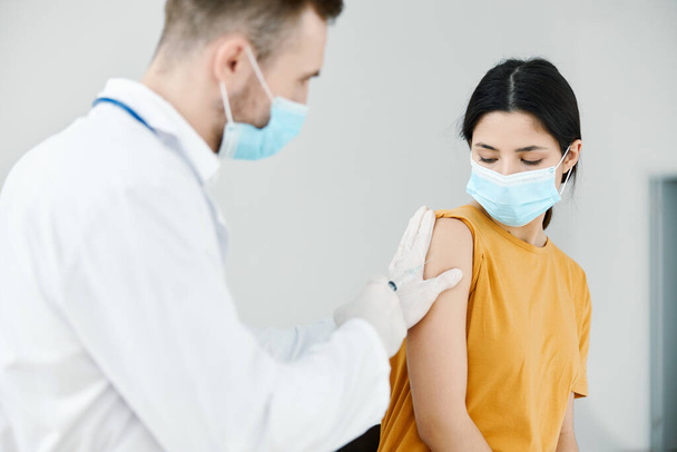 médico responsable inyecta la vacuna covid-19 en pacientes mujeres vacunación de hombro - Foto, Imagen