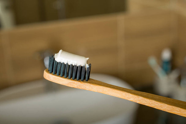 Escova de dentes de bambu com pasta de dentes na pia do banheiro. Fechar. - Foto, Imagem