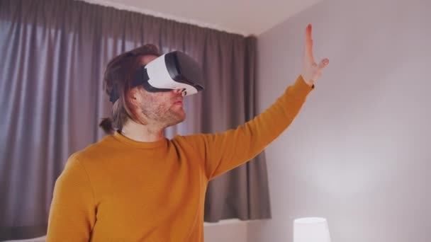 Hombre joven con auriculares VR experimentando realidad virtual - Imágenes, Vídeo