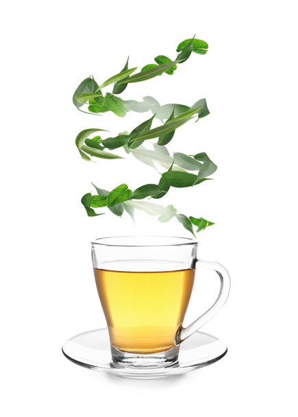 Чашка смачного гарячого чаю з листям зеленого чаю на білому тлі
 - Фото, зображення