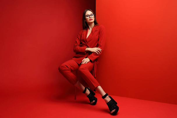 Fashion young woman in red suit. Red background. - Foto, Imagem