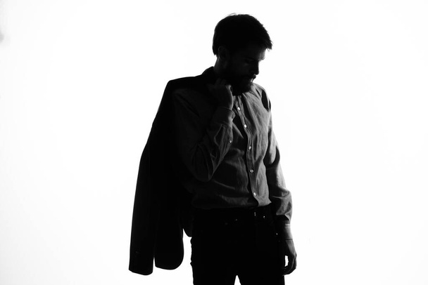 άντρας με κοστούμι που κρατάει ένα σακάκι στα χέρια του. Προφίλ συναισθημάτων σκιά σιλουέτας - Φωτογραφία, εικόνα
