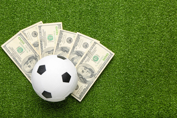 Pénz és focilabda színes háttérrel. A sportfogadás fogalma - Fotó, kép